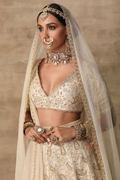 a woman wearing a bridal outfit and jewelry