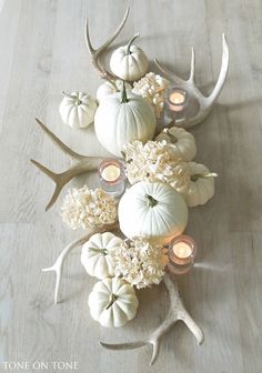 a table topped with antlers, candles and flowers