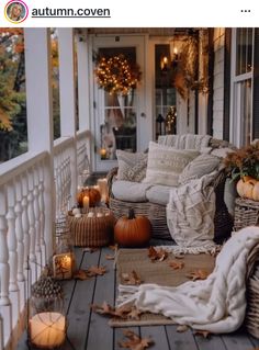 the porch is decorated for fall with pumpkins and wicker furniture on it, candles are lit up