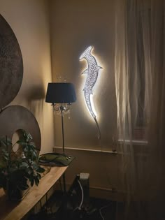 a lamp that is sitting on top of a table next to a wall mounted lizard