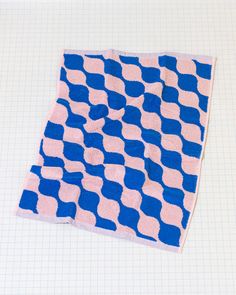 a blue and pink blanket sitting on top of a piece of paper