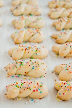 cookies with sprinkles are lined up on a baking sheet