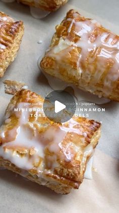 several pastries sitting on top of a piece of wax paper covered in icing