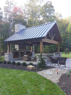 a covered patio with an outdoor fireplace and grill