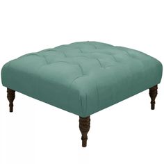 a grey ottoman with wooden legs and an upholstered foot rest in the middle