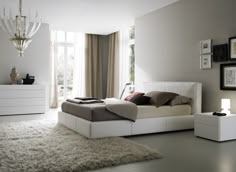 a bedroom with white furniture and carpeted flooring