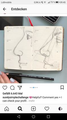 an open notebook with drawings on it and someone holding a pen in front of it