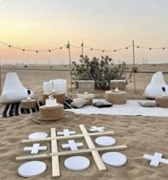 an outdoor seating area is set up in the sand with crosses and baskets on it