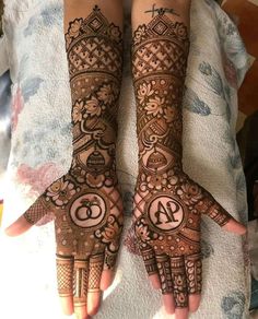 two hands with henna tattoos on them, one is showing the number forty and the other