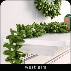 a christmas wreath on top of a white dresser