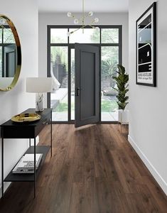 a hallway with wood flooring and white walls in the background is an entry way