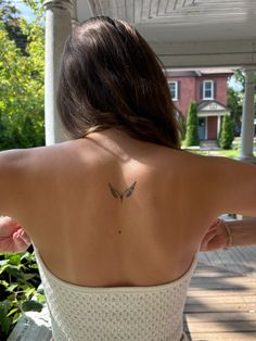 a woman with a butterfly tattoo on her back