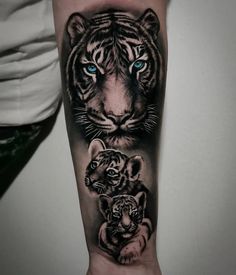 a tiger and cub tattoo on the right arm, with blue eyes in black and grey