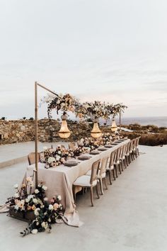 an outdoor table set up with flowers and candles