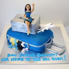 a cake with a woman sitting on top of suitcases and an airplane in the background