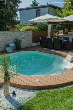 an outdoor pool with wooden decking and umbrellas in the back yard, surrounded by lawn furniture