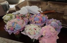 a bunch of flowers sitting on top of a table in front of a tv set