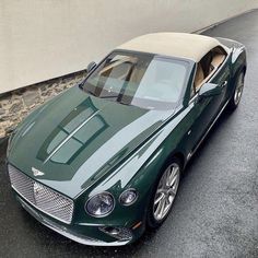 a green sports car parked in front of a building