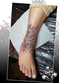 a woman's foot with a flower tattoo on her left side and the bottom part of her leg