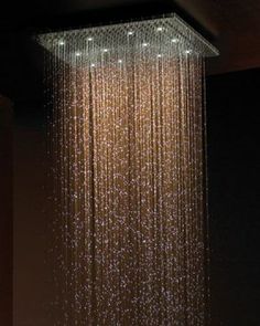 a shower head with water running down it's sides and lights on the side