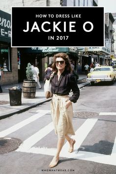 a woman walking across a cross walk in front of a restaurant on the corner of a busy city street