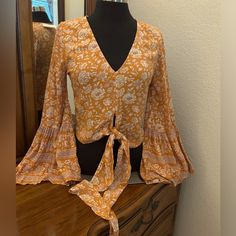 American Eagle Boho Peasant Top With Beautiful Flared Bell Sleeves. V Neckline And Ties At The Waist Line. Ptp Is 18 Inches And Length Is 18 Inches. As You Can Tell By The Ptp It Can Easily Fit A Small Maybe Even A Medium. Color Is Orange And Cream. Brand New With Tags. Fabric Is 100% Viscose. Very Soft And Light. Absolutely Gorgeous. Item 074. Orange Bohemian V-neck Top, Fall Peasant Printed Top, Fall Peasant Style Printed Top, Fall Peasant V-neck Top, Bohemian Rayon Top With Boho Print, Bohemian Boho Print Rayon Tops, Casual Flowy Tops With Boho Print, Flowy Casual Tops With Boho Print, Flowy Boho Print Casual Tops