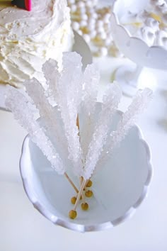 a cake with white frosting and sprinkles on it sitting on a plate