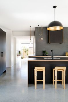 a kitchen with two stools next to an island