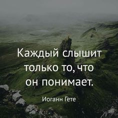 a person standing on top of a green mountain with a quote in russian above it