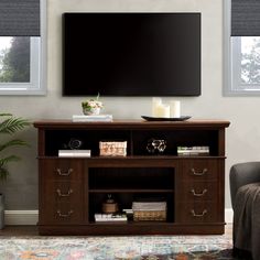 a flat screen tv mounted to the side of a wooden entertainment center in a living room