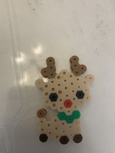 a white and brown pin with black dots on it's face is sitting on a table