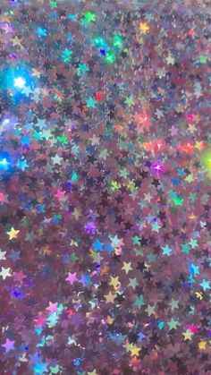 an image of many stars in the sky with colors that appear to be glitter or gold