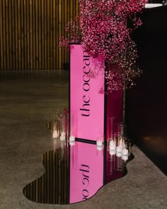 a pink box with candles and flowers in it