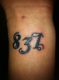 a small wrist tattoo with the letter f on it's left side and an om symbol in the middle