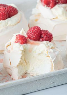 raspberry cheesecake with whipped cream and fresh raspberries on the top