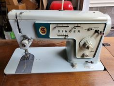 an old sewing machine sitting on top of a wooden table