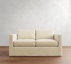 a white couch sitting on top of a wooden floor