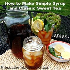 two mason jars filled with iced tea sit on a table next to a bowl of lemons