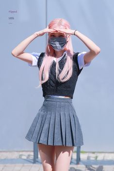 a woman with pink hair wearing a skirt and blindfold