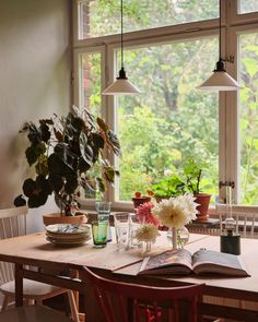 a dining room table with flowers and books on it