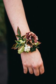 a close up of a person wearing a bracelet with flowers on it's wrist