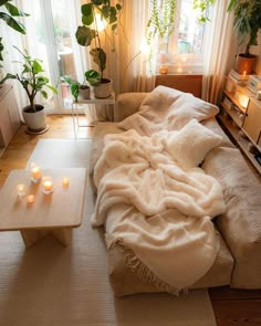 a living room filled with furniture and lots of plants on the windowsill, next to a coffee table