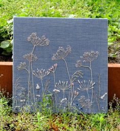 a blue canvas with flowers on it sitting in the grass