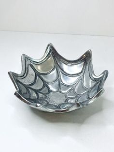 a silver bowl sitting on top of a white table