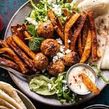 a plate full of food with pita bread and salad on the side next to it