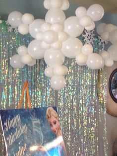 balloons are hanging from the ceiling above a frozen princess birthday party