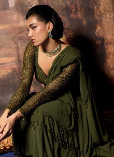 Embrace elegance with this olive branch embroidered blouse and ruffle sari set. The intricately embroidered full-sleeve blouse adds a touch of sophistication, perfectly complementing the graceful drape of the sari. The ruffle detailing enhances the overall look, creating a beautiful silhouette that’s ideal for special occasions. This ensemble beautifully merges traditional charm with modern style, ensuring you shine with confidence and grace. Designer Georgette Blouse With Ruffles, Green Georgette Saree With Ruffles, Long Sleeve Resham Embroidery Pre-draped Saree For Festive, Elegant Green Sharara With Ruffles, Embroidered Long Sleeve Pre-draped Saree For Reception, Designer Semi-stitched Ruffled Blouse Piece, Bollywood Style Blouse With Traditional Drape And Ruffles, Bollywood Style Blouse With Ruffles And Traditional Drape, Traditional Sharara With Embroidered Sleeves For Diwali