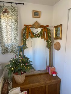 a mirror sitting on top of a wooden dresser next to a potted plant in front of it