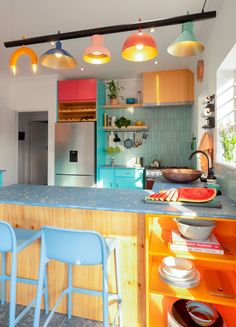 a kitchen with blue chairs and orange cabinets