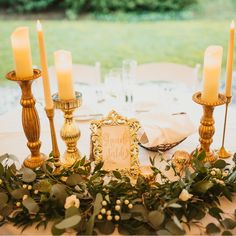 a table with candles and greenery on it